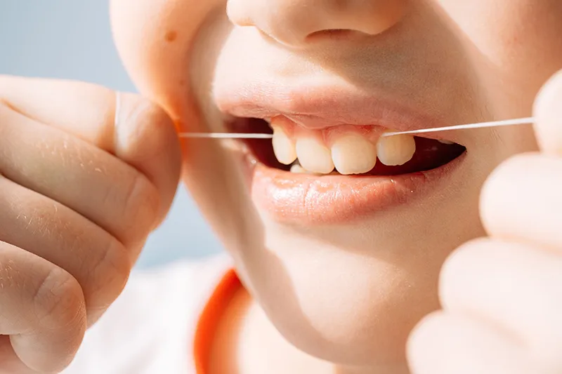 Child flossing teeth